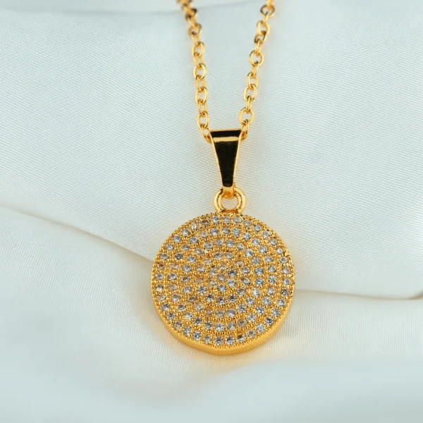 Golden glam jewellery with circular zirconia pendant